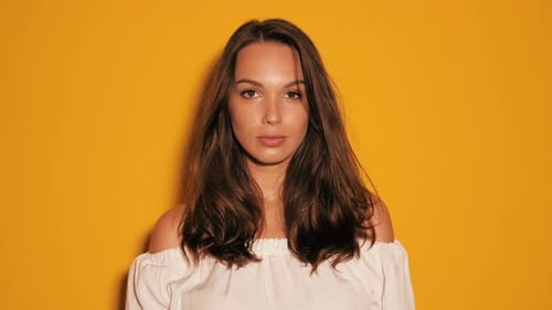 Woman Smiling and Laughing Against Yellow Background