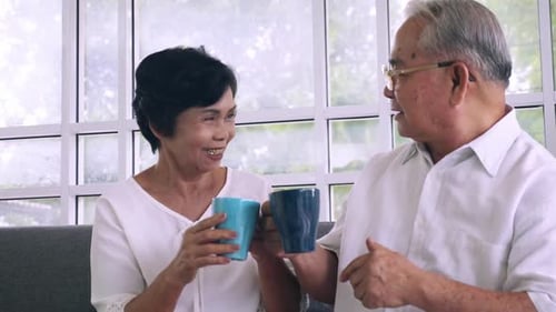 Elderly Couple Enjoying Hot Drinks and Conversation