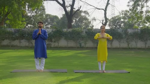 Man and Woman Doing Yoga Outdoors