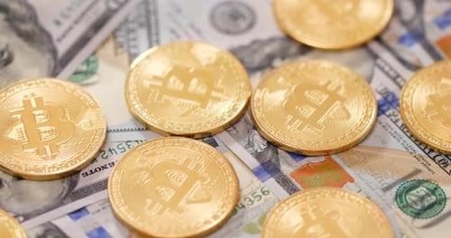 Close Up of Gold Bitcoins on Dollar Bills