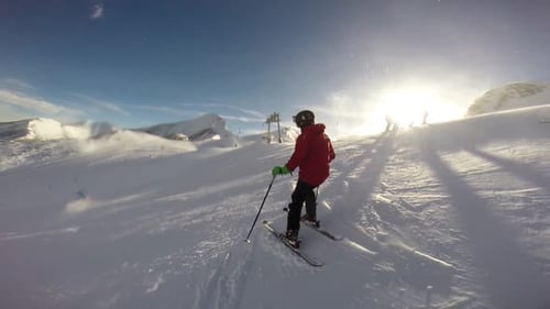Young man skiing down a snow covered mountain.