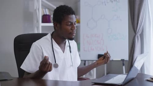 Doctor Meditating at Desk in Medical Office