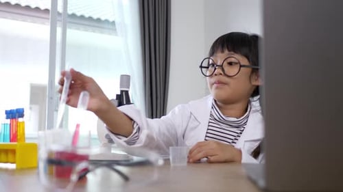 Young Girl Scientist Conducts Science Experiment With Microscope