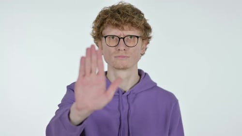 Rothaariger junger Mann mit Stoppschild von Hand, weißer Hintergrund