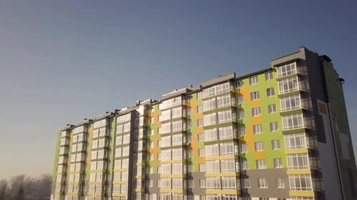 Aerial footage of a tall residential apartment building with many windows and balconies.