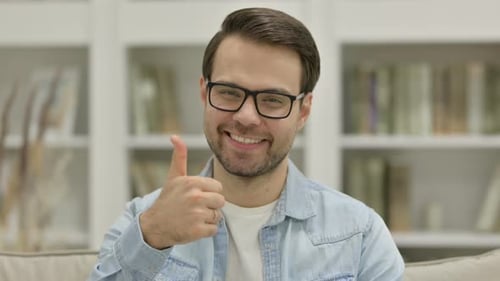 Young Adult Smiling and Giving Thumbs Up