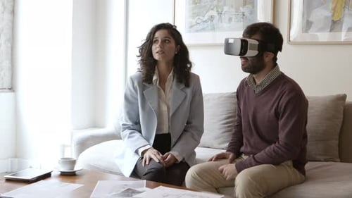 Kaukasischer Mann trägt Virtual-Reality-Headset und spricht mit Innenarchitektur