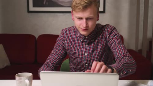 Young Adult Typing on Laptop Indoors