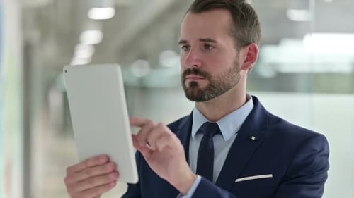 Businessman Using Tablet Device in Bright Office Space