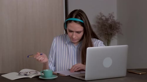 Woman Studying with Laptop and Headphones at Home