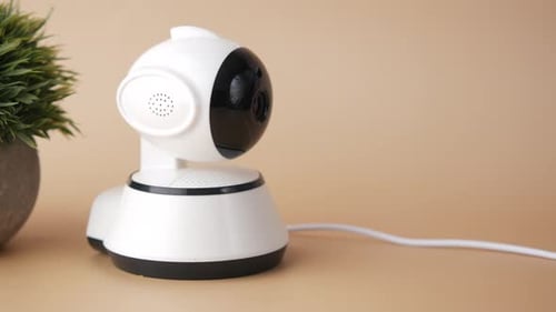 CCTV-Überwachungskamera arbeitet auf hellem orangefarbenem Hintergrund