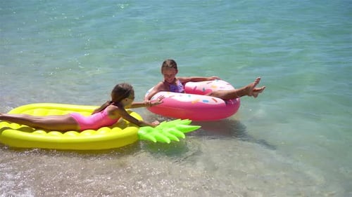 Kleine Mädchen, die in den Sommerferien Spaß am Tropical Beach haben und zusammen spielen