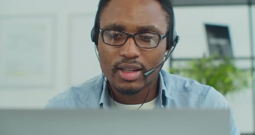 Young Man with Headset Talking to Computer