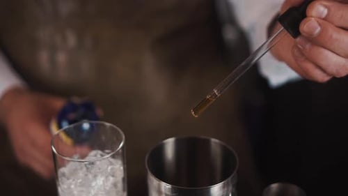 Dropper adding flavoring to cocktail shaker