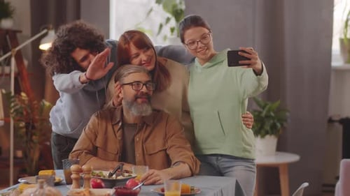 Family Smiles for a Photo at Dinner Table