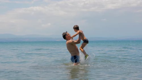 Father and Son Play in Ocean Water