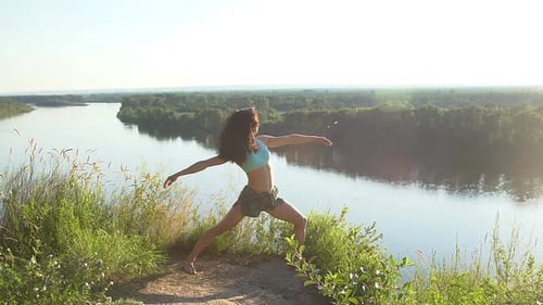 Woman Doing Yoga Exercise Outdoors by River