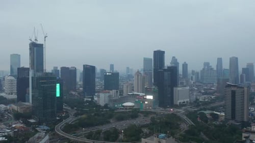 Aerial Dolly Shot Flying Over Multi Lane Highway Intersection Towards Skyscrapers in Urban City