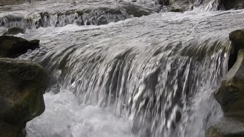 Fließender klarer Flusswasserstrom. Schneller Fluss mit Wasserfall