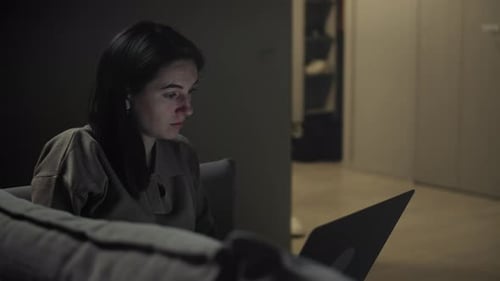 Woman works in her living room at night.