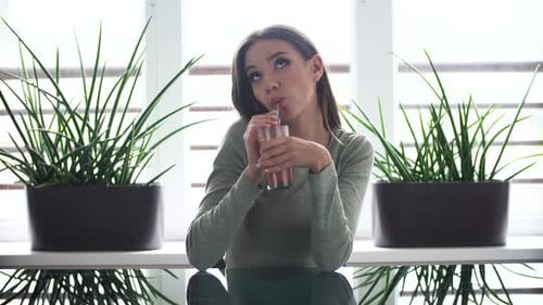Smiling Woman Drinking Juice at Home