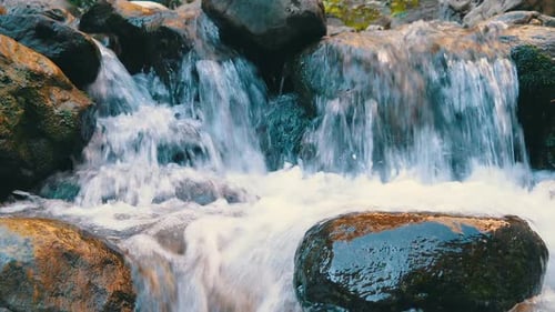 Small Waterfall Cascading Over Rocks in Nature