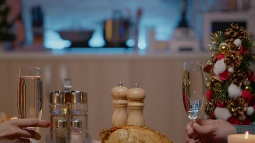 Close Up of Couple at Festive Dinner Clinking Glasses of Champagne