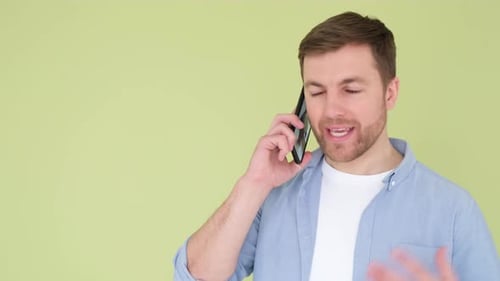 Angry Man Talking on Smartphone Isolated on Background in Studio