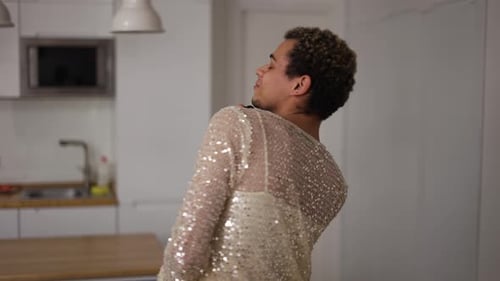 Um homem transexual em um vestido dançando com um novo vestido preto