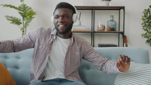 Man Listening to Music and Dancing on Couch