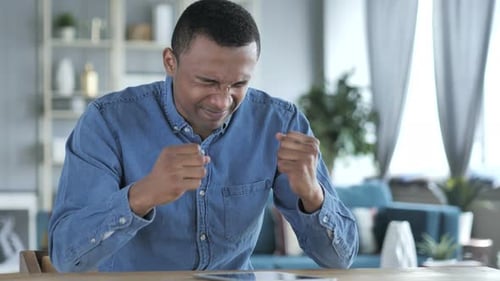 Young Man Frustrated Using Tablet at Home