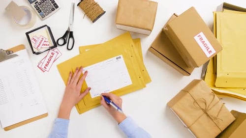 Woman Signing Parcel Envelopes at Post Office