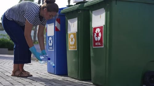 Woman Recycles Plastic Bottle in Urban Setting