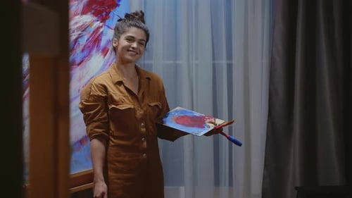 Artist Smiling with Palette in Front of Canvas