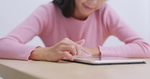 Woman Uses Tablet Device At Home