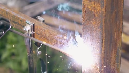 Closeup Fixing Metal Fence with Welding Tool at House