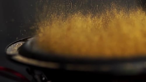 Golden Dust Bouncing on Black Speaker Membrane