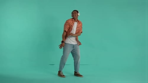 Man Grooving Energetically with Headphones in Studio