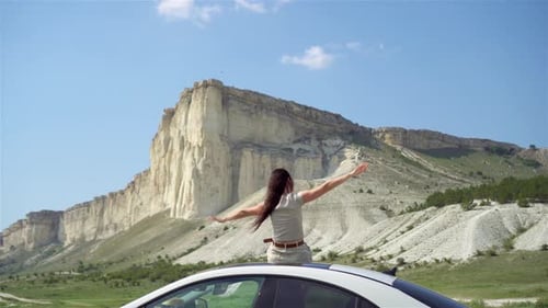 Woman on Car Roof Enjoying Mountain View