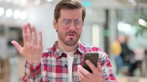 Frustrated Young Adult Reacts to Mobile Device