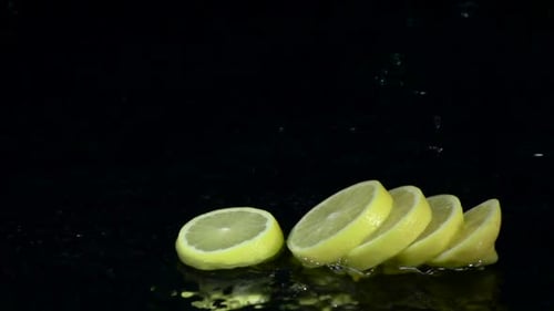 Lemon Dissolves Into Slices When It Falls Into the Water. Black Background. Slow Motion