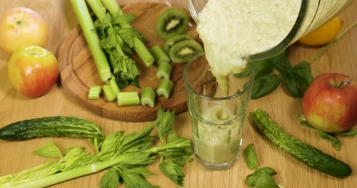 Gießen Sie frisch gepressten Bio-Smoothie aus grünem Gemüse und Obst in das Glas
