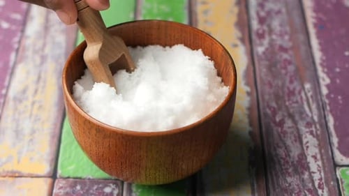 Bowl of White Granules with Wooden Scoop