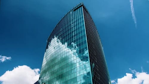 Reflective Skyscraper Against Blue Sky with Clouds