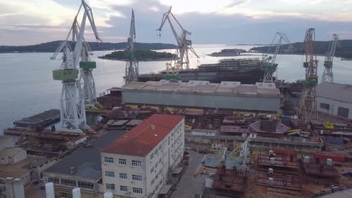 Shipyard Aerial View with Cranes Under Cloudy Sky