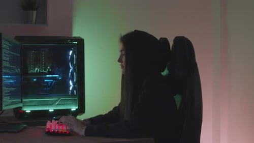 Female at Computer Coding in Dark Room
