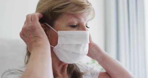 Senior Woman Adjusting a White Face Mask