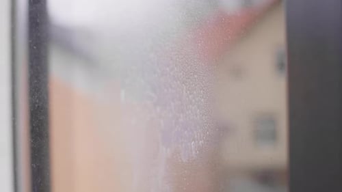 Close up of caucasian woman washing the window at home. Shot with RED helium camera in 8K.
