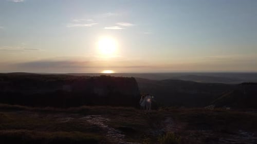 Two Travelers Stand on Top of the Mountain and Watch the Beautiful Sunset