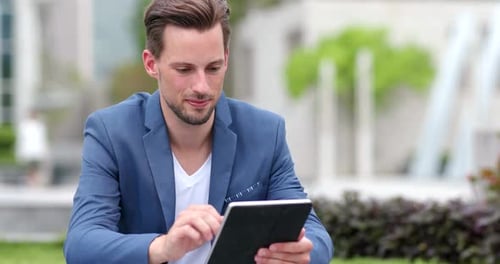 Man Using Tablet in Urban Park